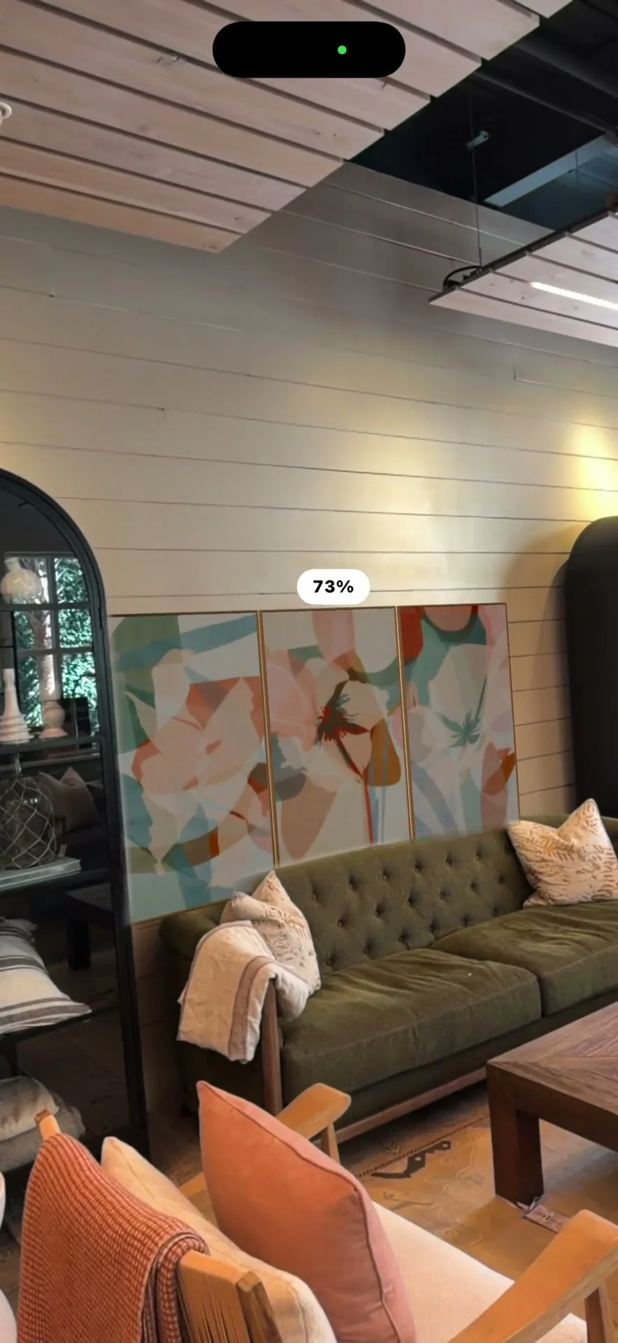 A phone screen shows the AR camera view mid-scan, with a live percentage readout, placed in a real styled living room.